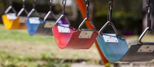 Colorful swings in a row at a children's park.