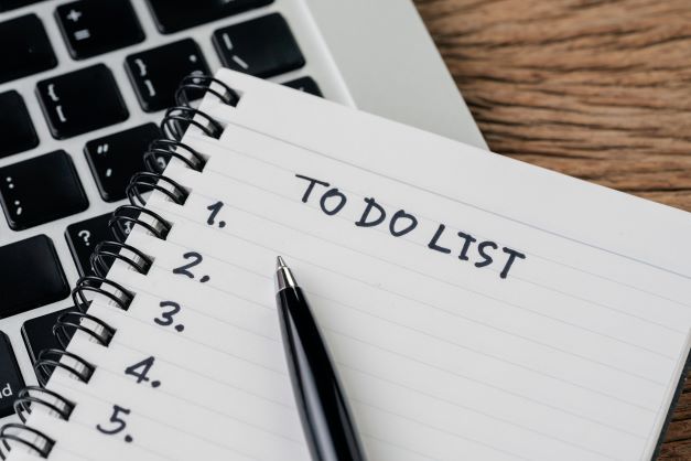 to do list with pen and notebook on keyboard