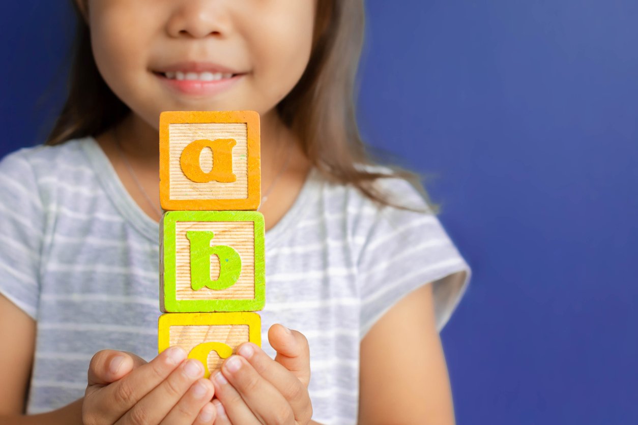 girl holding abc blocks